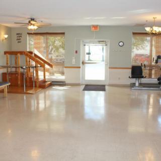 An interior view of a building lobby with large windows and handrails.