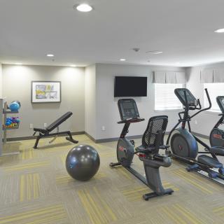A modern gym with various fitness equipment including exercise bikes and elliptical machines.