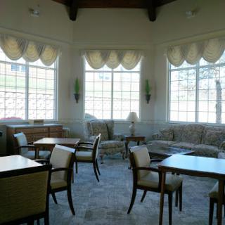 A cozy lounge area featuring elegant furniture and large windows, inviting relaxation and social interaction.