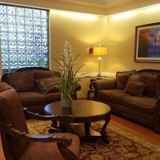 A cozy living room with comfortable sofas, a round table, and a warm lamp.