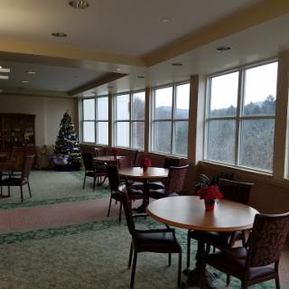 A spacious lobby area with tables and chairs, decorated for the holiday season.
