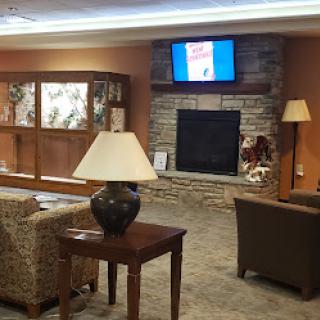 A cozy living room setting with comfortable seating, a television, and a fireplace.