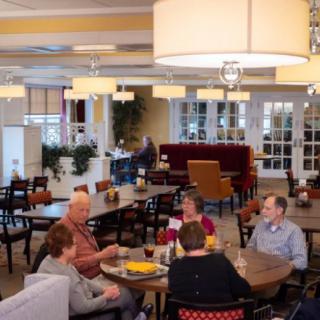 A group of people having a conversation in a cozy restaurant dining area.