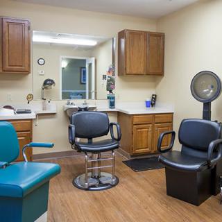 A neatly arranged hair salon with various chairs, mirrors, and equipment.