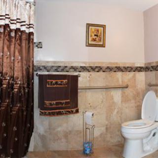 A cozy bathroom with decorative curtains and towel.