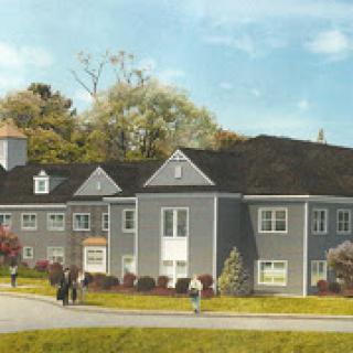 A modern residential building surrounded by greenery, with people walking in the foreground.