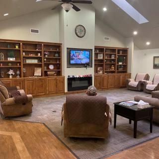 A spacious living room with comfortable seating, a fireplace, built-in bookshelves, and a television.