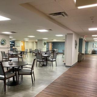 An empty dining area with tables and chairs arranged in a spacious indoor setting.