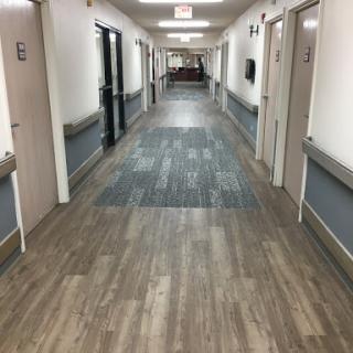 A long, well-lit hallway with multiple doors and modern flooring.