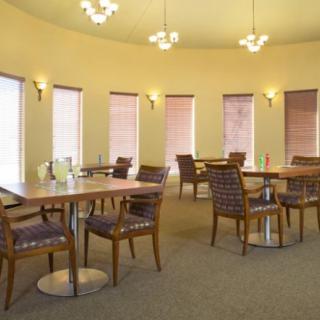 A well-lit dining area with neatly arranged tables and chairs.