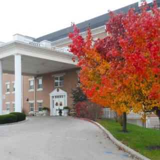 A building entrance with a vibrant tree displaying autumn colors.