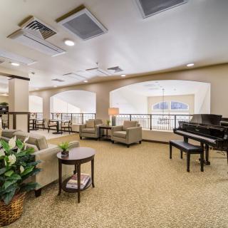 A spacious living room with comfortable seating and a grand piano.