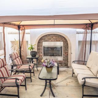 Cozy outdoor gazebo with a fireplace and comfortable seating area.