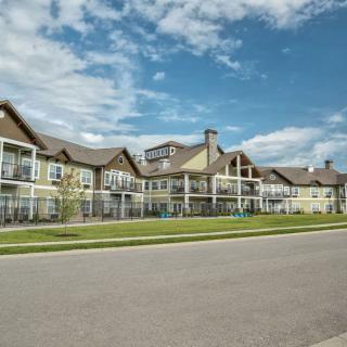A residential building with a clear blue sky and road in the foreground.