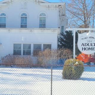 A serene view of an adult home surrounded by snow in winter.