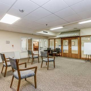 A spacious waiting room with neatly arranged chairs and a reception area in an office setting.