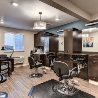 A modern hair salon interior featuring styling chairs, mirrors, and sleek wooden cabinetry.