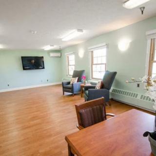 A bright and spacious living room with comfortable seating and a wall-mounted television.