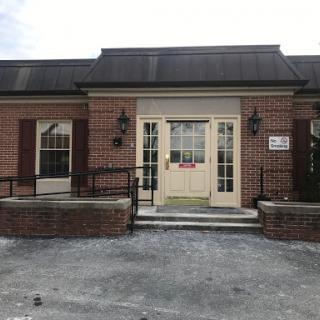 A welcoming entrance to a brick building with double doors and decorative lighting.