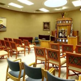 An interior view of a synagogue with arranged seating and religious elements.