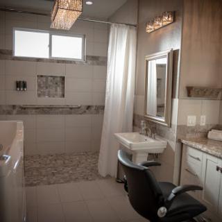 A modern bathroom featuring a spacious shower area, stylish vanity, and elegant lighting.