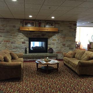 A cozy living room with a stone fireplace, two sofas, and a coffee table.