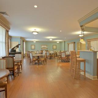 Spacious and elegantly designed dining room with tables, chairs, and a bar area.