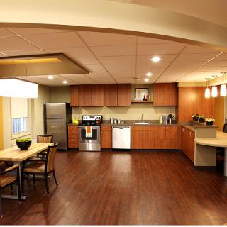 A modern kitchen featuring wooden cabinets, stainless steel appliances, and a spacious dining area.