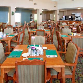 An empty dining area in a restaurant with neatly arranged tables and chairs.