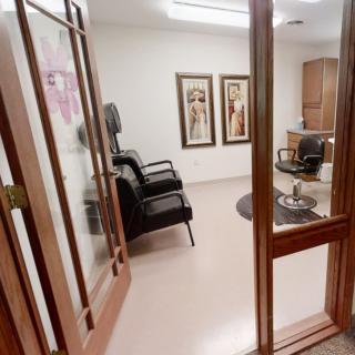 Interior of a hair salon with chairs and framed artwork on the wall.