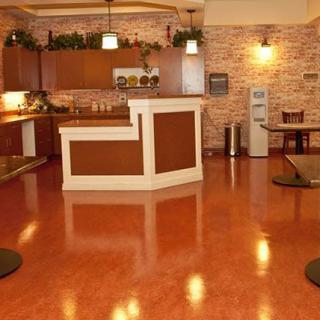 A modern kitchen and reception area with wooden floors and warm lighting.