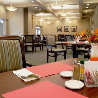 A cozy restaurant dining area with neatly arranged tables and chairs, featuring decorative elements and warm lighting.