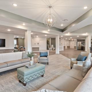 A modern and spacious lobby with elegant seating and a central chandelier.