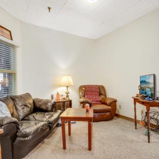 A cozy living room with a sofa, armchair, coffee table, and television.