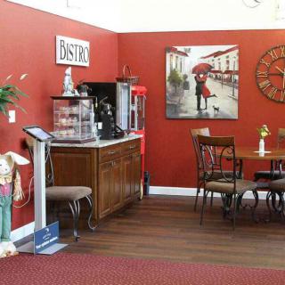 A cozy bistro interior with a coffee station, seating area, and wall artwork.