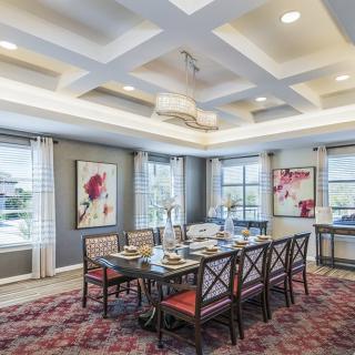 Elegant dining room with a large table, stylish chairs, and modern artwork.