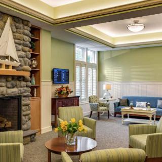 A cozy living room with a fireplace, comfortable seating, and green walls.