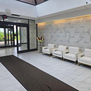 A spacious and modern lobby featuring white seating and elegant decor.
