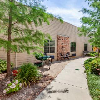 A landscaped pathway with benches and greenery alongside a building.