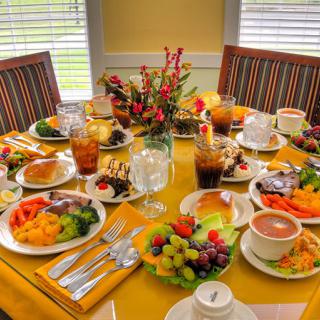 A colorful breakfast spread with various dishes and drinks elegantly arranged on a dining table.