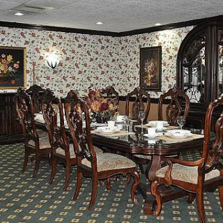 A classic and elegantly furnished dining room with a formal table setting.