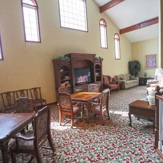A spacious living room with a dining area, featuring elegant furniture and large windows.