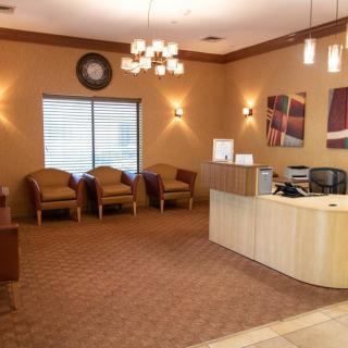 A well-lit waiting room with comfortable chairs and a reception desk.