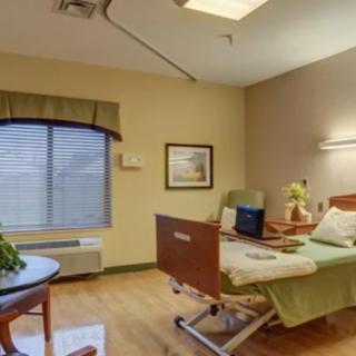 A comfortable hospital room with a bed and seating area.