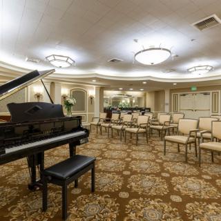A luxurious concert hall with a grand piano and arranged seating.