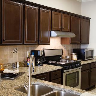 Modern kitchen with dark cabinets and granite countertops.