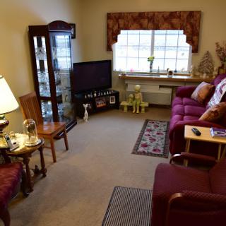 A cozy living room featuring a comfortable sofa, a television setup, and decorative furnishings.