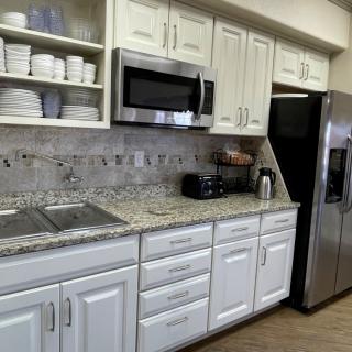 Modern kitchen with white cabinets and granite countertops.