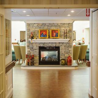 A cozy living room interior featuring a stone fireplace and comfortable seating.