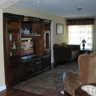 A cozy living room with a large entertainment center and comfortable seating.